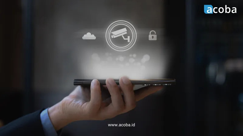 Tangan memegang perangkat dengan ikon kamera CCTV, awan, dan gembok melayang di atasnya