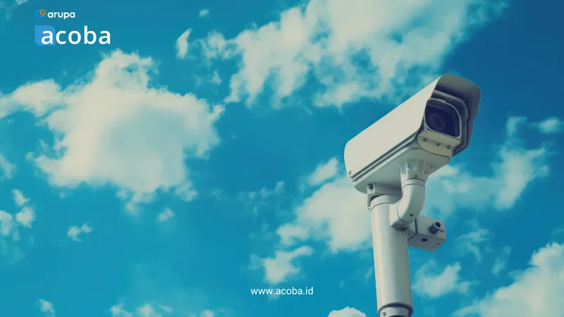Kamera CCTV pada tiang dengan latar langit biru berawan