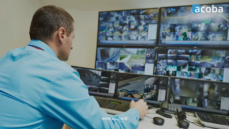 Petugas keamanan memantau dinding monitor CCTV di ruang kontrol